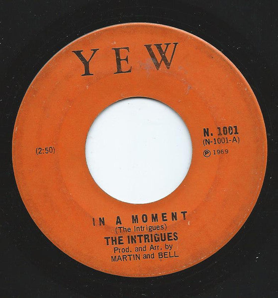 The Intrigues : In A Moment (7", Single, Ora)